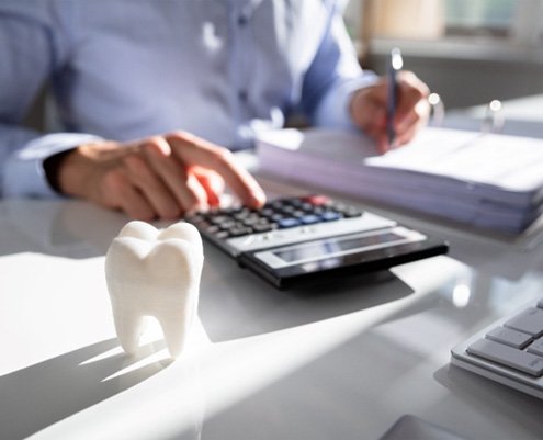 a person calculating the cost of dental implants in Richardson